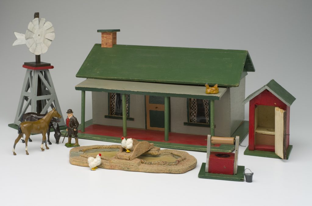 Wooden toy farm house, windmill, wishing well, duck pond and outside toilet with lead farm animals and farmer. 